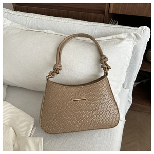 Détails de la texture en cuir tissé marron et de l'élégante boucle dorée du sac à main