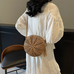 Handcrafted round straw crossbody bag with tassels and woven strap for beach fashion