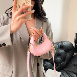 Pink matte leather crescent mini handbag with gold hardware and crossbody strap