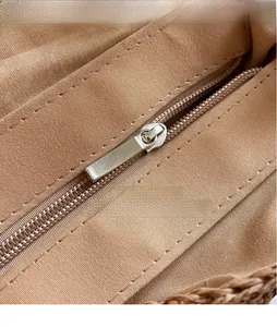 Detail of smooth silver metal zipper and durable twill lining on hand-woven bag