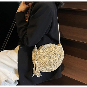 Detail of round straw bag showing fine woven texture and wood bead tassel decoration