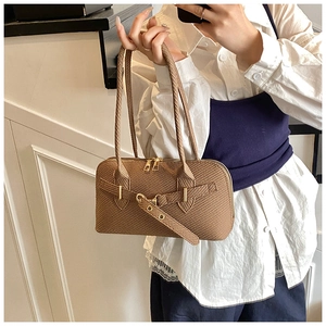 Detail of the brown vintage bowling bag showing textured leather and gold buckle hardware