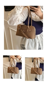 Detail of a brown woven texture retro handbag with gold metal hardware and slim handles