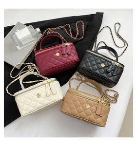 Detailed display of four quilted leather handbags with gold camellia flowers and chain straps