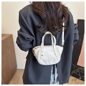 Detail of cream mini bucket bag with gold lettering and metallic chain strap detail