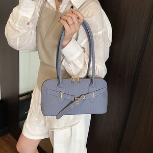 Light blue textured bowling bag with gold hardware and long handles shown on a model