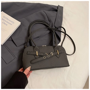 Detail of dark grey fabric pillow bag with gold buckles and leather strap accents