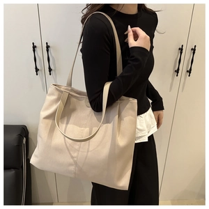 Detailed close-up of large canvas tote bag showing fine fabric texture and stitching