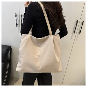 Close-up of beige tote bag with Fashion & Bags leather patch and vertical stitching