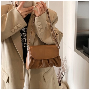 Close-up of caramel pleated cloud bag with silver metal chain strap and leather texture