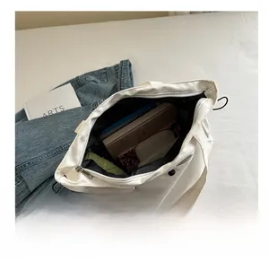 Top view showing the large capacity interior of a white canvas tote bag with zipper