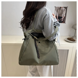 Detail view of large olive green tote bag with side drawstring and checkered strap