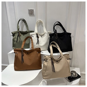 Close-up of five large canvas tote bags in earthy tones with drawstring side details