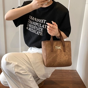 Vintage-Eimertasche in Braun mit Retro-Textur und edler goldener Metallplakette