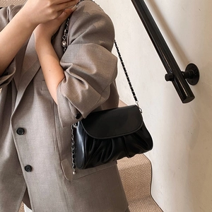 Chic black pleated cloud bag with silver chain strap shown as a stylish crossbody bag