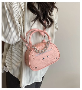Dettaglio mini borsa rosa effetto coccodrillo con borchie e catena in metallo