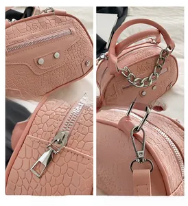 Dettagli della borsa rosa motivo coccodrillo con borchie metalliche e manico a catena