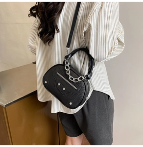 Detail of black faux crocodile skin texture and silver studs on stylish crossbody bag