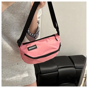 Détail du sac bandoulière demi-lune en nylon rose avec large sangle noire et logo