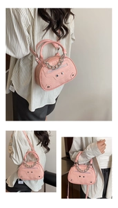 Tre angolazioni della mini borsa rosa effetto coccodrillo con borchie e catene