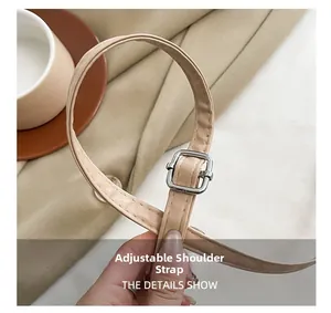 Detail showing adjustable beige leather shoulder strap with polished silver metal buckle