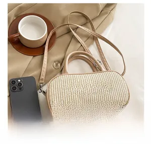 Top-down view of woven crossbody bag with BLONMAY embroidery next to phone and coffee cup