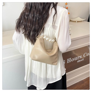 Detail showing elegant pearl handle on light beige PU leather shoulder bag with gold chain