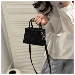 Detail of black woven crossbody bag featuring Intrecciato texture and gold hardware