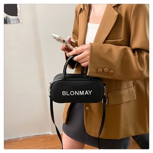 Detail of BLONMAY black bowling bag with white lettering and woven texture