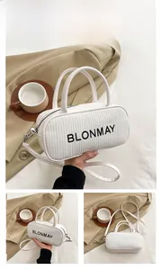 Detail of white bowling bag with woven texture and black BLONMAY logo with strap