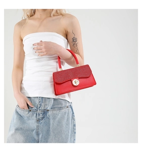 Detailed close-up of a red woven handbag with sequin flap and gold circular twist lock