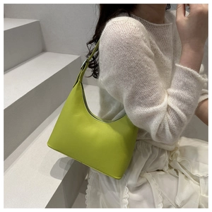 Adjustable strap detail on a bright green crescent underarm bag with silver buckle
