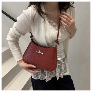 Detailed view of dark red faux crocodile leather texture with silver star charm