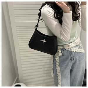 Detail showing high-quality black crocodile-textured leather and silver star logo on bag