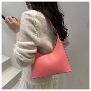 Minimalist pink underarm bag shown on shoulder for sizing and fit perspective