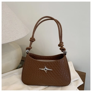 Detail of a brown woven shoulder bag featuring a silver star logo and knotted rope handle
