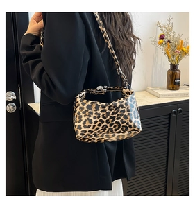 Close-up of leopard print underarm bag featuring adjustable leather strap and silver buckle