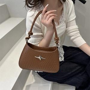 Brown woven texture handbag with silver star buckle and knotted strap on white dress model