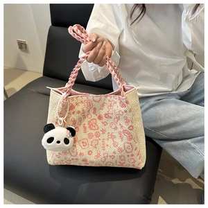 Détail du sac cabas d'été tissé avec anses en corde rose et breloque panda en peluche