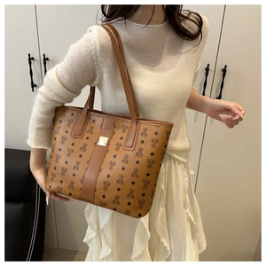 Detail of a large brown leather tote bag with bear monogram pattern and gold buckle