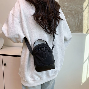 Minimalist black canvas drawstring crossbody phone bag with adjustable shoulder strap