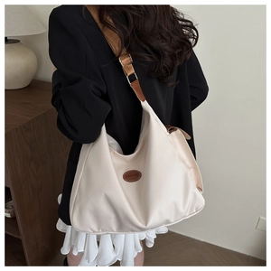 Fashionable beige nylon tote bag with brown leather straps shown on a model side view