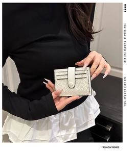 Detail of white woven texture card holder with snap closure and multi-card slot interior