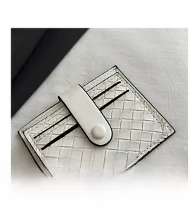 Detail shot of white woven card holder with snap closure and multi-slot texture