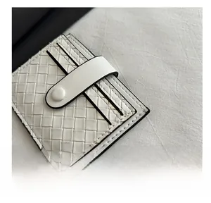 Detail of white woven leather wallet featuring premium texture and secure snap button closure