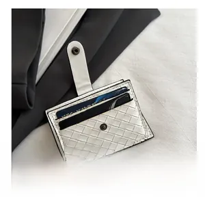 Detail showing white woven card holder with secure snap button and multi-slot capacity