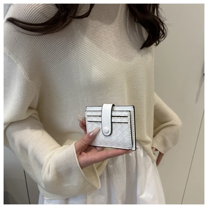 Close-up of white woven card holder with snap button held by a person in neutral attire