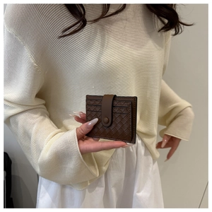 Close-up of brown woven texture card holder with secure snap button strap closure