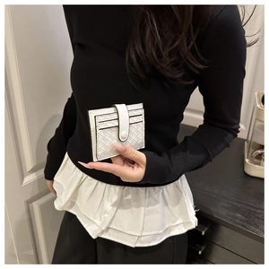 Close-up of white woven leather card holder with multiple slots and snap button held by hand