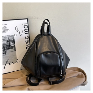 Detail of minimalist black geometric backpack with irregular design and front zipper pocket
